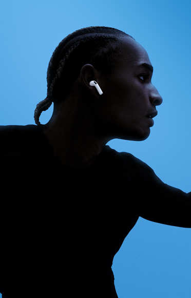 Človek s nasadenými slúchadlami AirPods 4.
