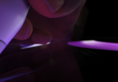 Egy kéz írásra kész helyzetben tartja az Apple Pencil Prót. A ceruzahegy egy képernyőhöz ér, amelyen fénylő zöld színnel húzott vastag vonások látszanak.
