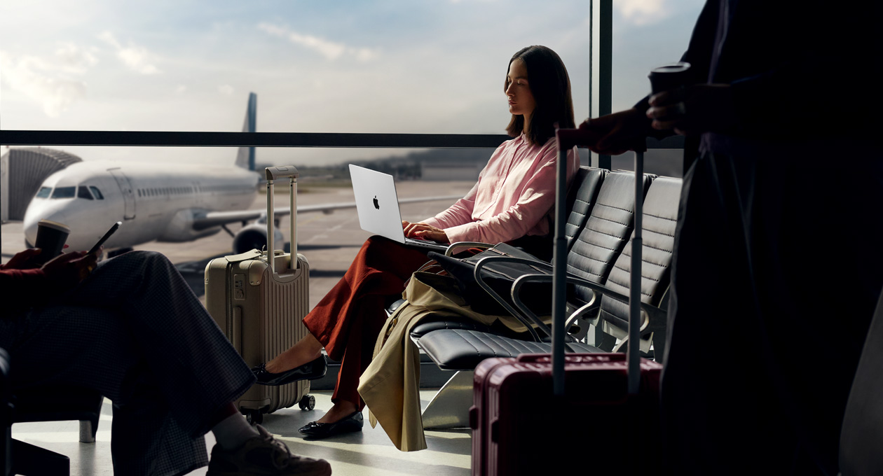Iemand op een vliegveld gebruikt een MacBook Pro